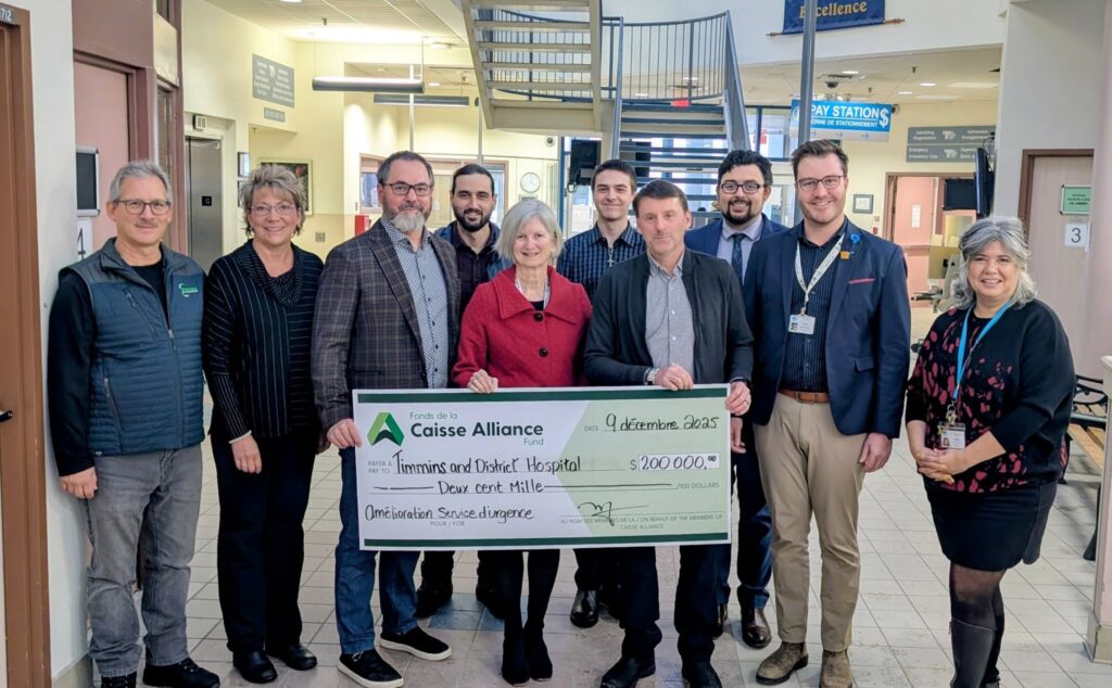 A group from TADHF and Caisse Alliance hold a big donation cheque